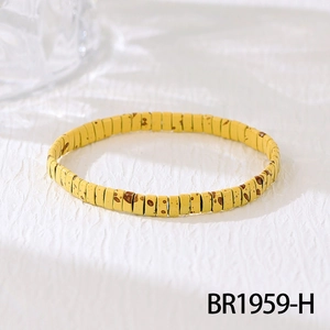 Detail of yellow tile stretch bracelet with brown spotted texture in Bohemian style
