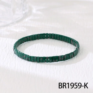 Detailed macro view of dark green flat glazed beads with brown speckles on elastic cord