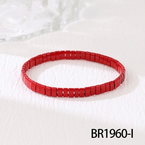 Gros plan détaillé des perles Tila rouges sur un bracelet bohème minimaliste et chic
