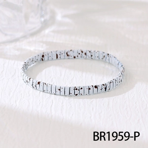 Detail of bohemian handmade woven bracelet with square dalmatian stone pattern beads