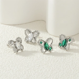 Detailed macro view of butterfly earrings with emerald green and white marquise cut zircons