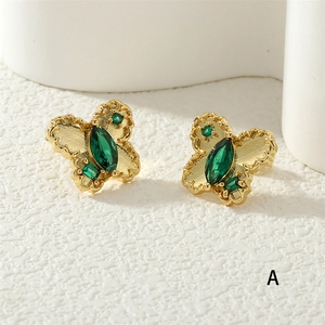 Close-up of gold butterfly stud earrings with marquise and square green zircon stones