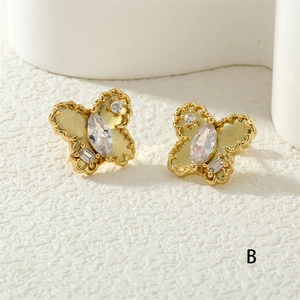 Detailed macro view of golden butterfly stud earrings with sparkling zircon gemstones