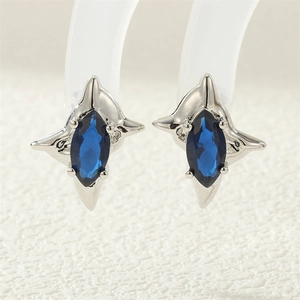 Macro shot of silver four-pointed star stud earrings with marquise-cut navy blue zircon