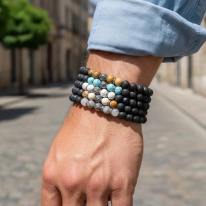 Detailansicht von Boho-Armbändern mit Türkis und Lavastein am Handgelenk eines Mannes