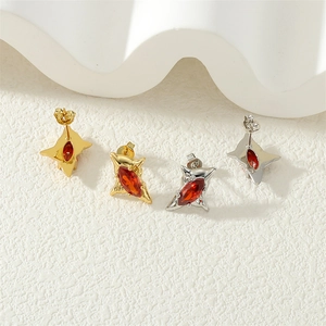 Macro view of marquise-cut red gems set in geometric star-shaped studs with gold and silver