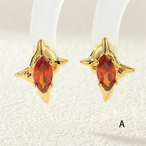 Detailed macro of gold irregular star earrings with marquise-cut orange zircon stones