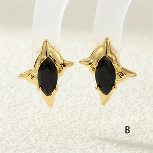 Macro shot of gold starburst earrings with black marquise cut zircon stones