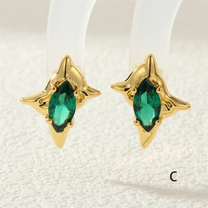 Macro shot of gold star earrings featuring marquise-cut green zircon gemstones