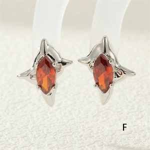 Detailed macro of silver four-pointed star stud earrings with marquise-cut red zircon stones