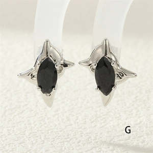 Macro shot of silver four-pointed star earring with black marquise cut zircon gemstone