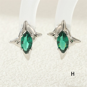Close-up of silver star earrings featuring marquise-cut green zircon stones