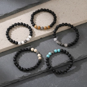 Detail von fünf Stapelarmbändern mit Türkis, Tigerauge und matten Lavastein-Perlen