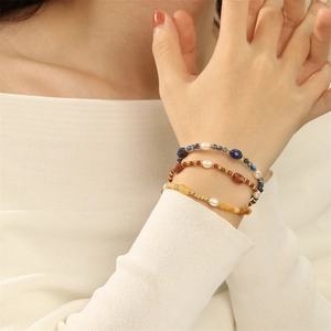 Detailweergave van een drielaagse armband in boho-stijl met parels en natuurlijke edelstenen