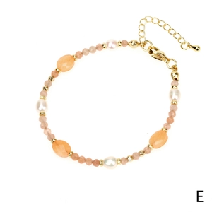 Detail van handgemaakte armband met parels, oranje natuursteen en gouden sluiting
