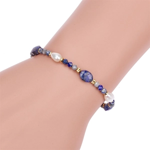 Detail van lapis lazuli kralenarmband met natuurlijke parels en gouden accenten