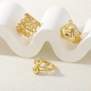 Three gold rings set featuring floral pattern, tiger head design, and double gold bead band