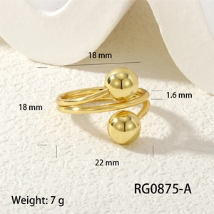 Detailed close-up of a double spiral gold ring with polished spheres on stone background
