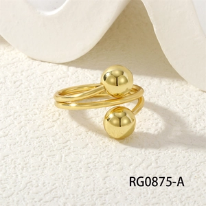Detailed view of the golden spiral ring with polished metal spheres on a white background