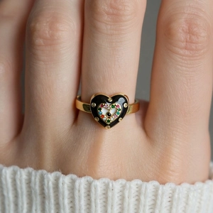 Macro shot of gold-plated heart devil eye ring with colorful zircons and black enamel
