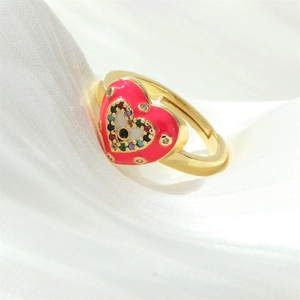 Macro detail of heart evil eye ring with pink enamel and colorful zircons on silk