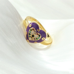 Detail of golden heart ring with purple enamel and colorful zircon evil eye design