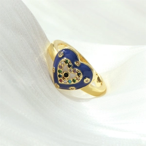 Detailed macro of golden heart ring with blue enamel and colorful evil eye zircons