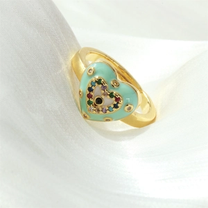 Detail of heart ring featuring colorful evil eye gemstones and mint green enamel