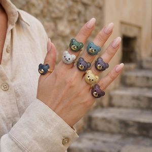 Detailaufnahme der Bärenringe mit bunten Zirkonia-Steinen und goldenem Ringband