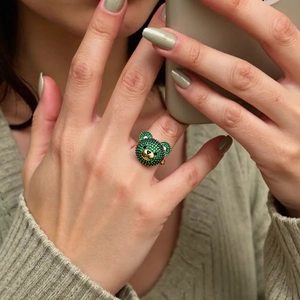 Schicker 3D Teddybär Ring mit grünen Zirkonia auf der Hand eines weiblichen Models
