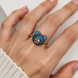Detailansicht eines vergoldeten Ringes mit einem 3D-Bären besetzt mit blauen Kristallen