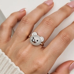 Detailaufnahme eines silbernen Bärenrings mit Zirkon-Mikropavé am Finger getragen