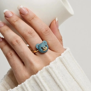 Detailansicht eines 3D-Bärenrings mit blauen Zirkonia auf vergoldetem Gehäuse