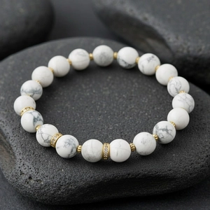 White gemstone beaded bracelet detail shot, elegant gold spacer beads, elastic stretch design.