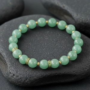 Green gemstone beaded bracelet with gold spacers and sparkling rhinestone rings, elegant stretch design.