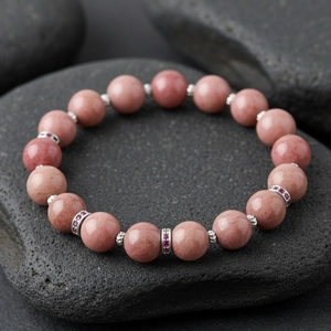 Exquisite semi-precious stone beaded bracelet detail shot, elegant pink round beads with metal spacers.