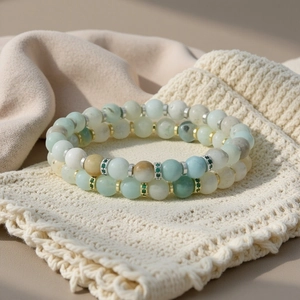 Detailopname van een dubbellaags boho-kralenarmband van halfedelstenen met gouden en zilveren accenten.