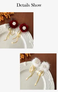Detail of plush earrings with pearl flowers and golden tassels in red and white