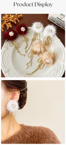 Detail of plush pearl flower earrings with long gold beaded tassels in three soft colors