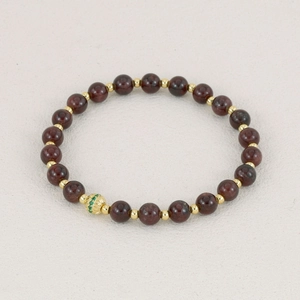 Tourmaline gemstone bracelet with deep red beads and golden hollow center charm