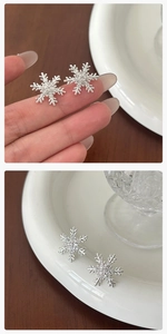 Primer plano de pendientes de copo de nieve plateados con circonitas sobre fondo de madera