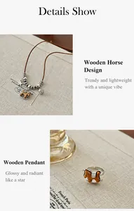 Detail shot of wooden rocking horse pendant necklace with leather cord on white background