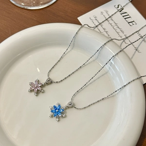 Elegante rotierende Schneeflocken-Anhänger mit rosa und blauen Steinen auf Silberperlenketten