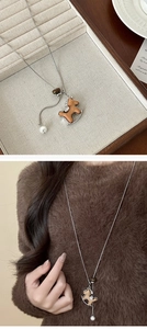 Dettaglio del ciondolo a cavallo a dondolo in legno su una lunga collana a catena d'argento