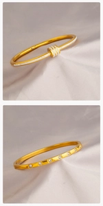 Dettaglio di bracciali dorati con zirconi incastonati su elegante sfondo di raso
