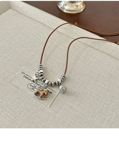 Dettaglio della collana con ciondolo a cavallo a dondolo in legno e stelle vintage