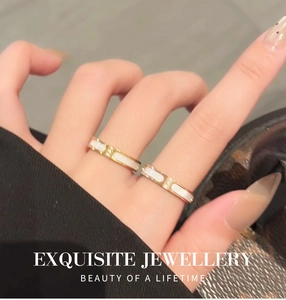 Detailopname van elegante gouden titanium ringen met witte schelp en zirkoniasteentjes