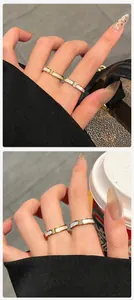 Detailweergave van gouden titanium stalen ring met wit parelmoer en zirkonia