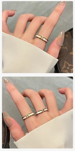 Detailopname van gouden titaniumstalen ringen met witte schelpinleg en zirkonia-accenten