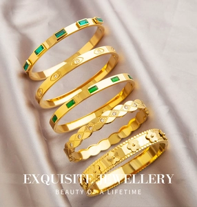 Vue détaillée d'un ensemble de cinq bracelets dorés avec pierres précieuses vert émeraude